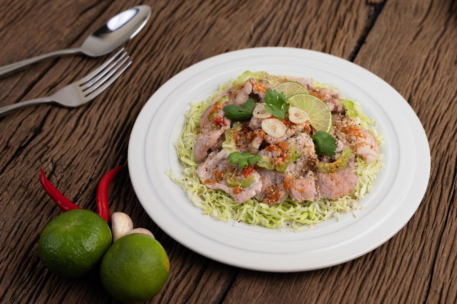 Spicy lime pork salad with galangal, chili and tomatoes photo