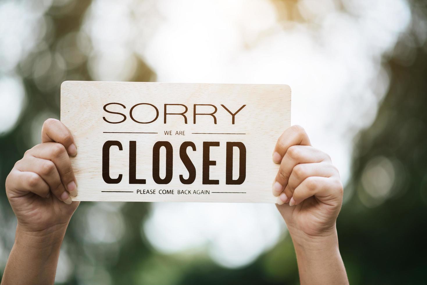 Girl holding a closed sign photo