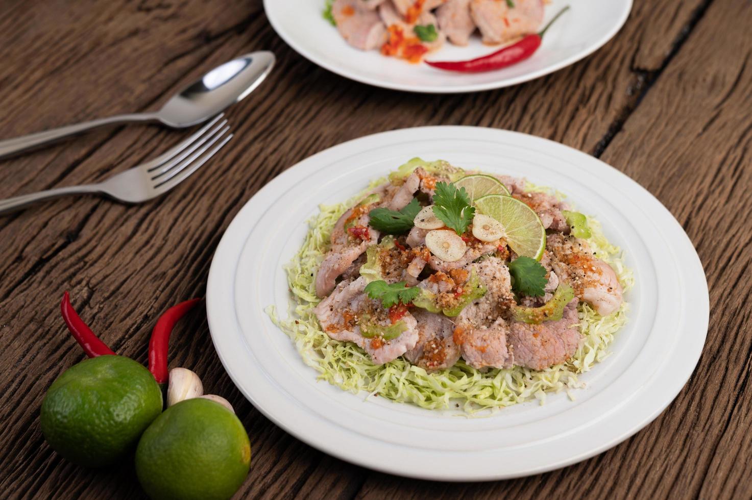 Spicy lime pork salad with galangal, chili and tomatoes photo