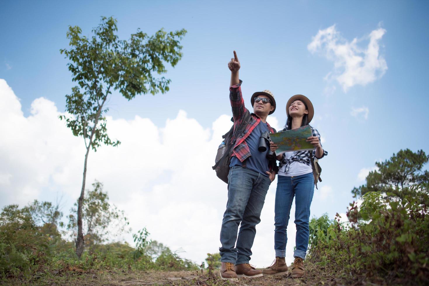 Dos jóvenes viajeros con mochilas en selva verde. foto