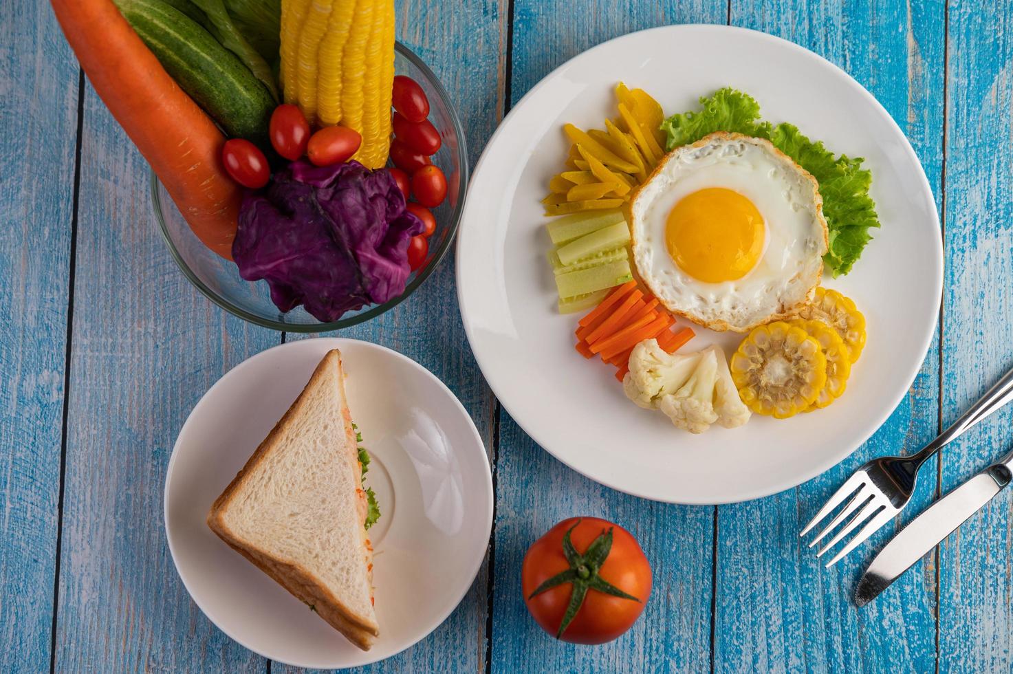 Fried egg breakfast with egg, salad, pumpkin, cucumber, carrot and corn photo