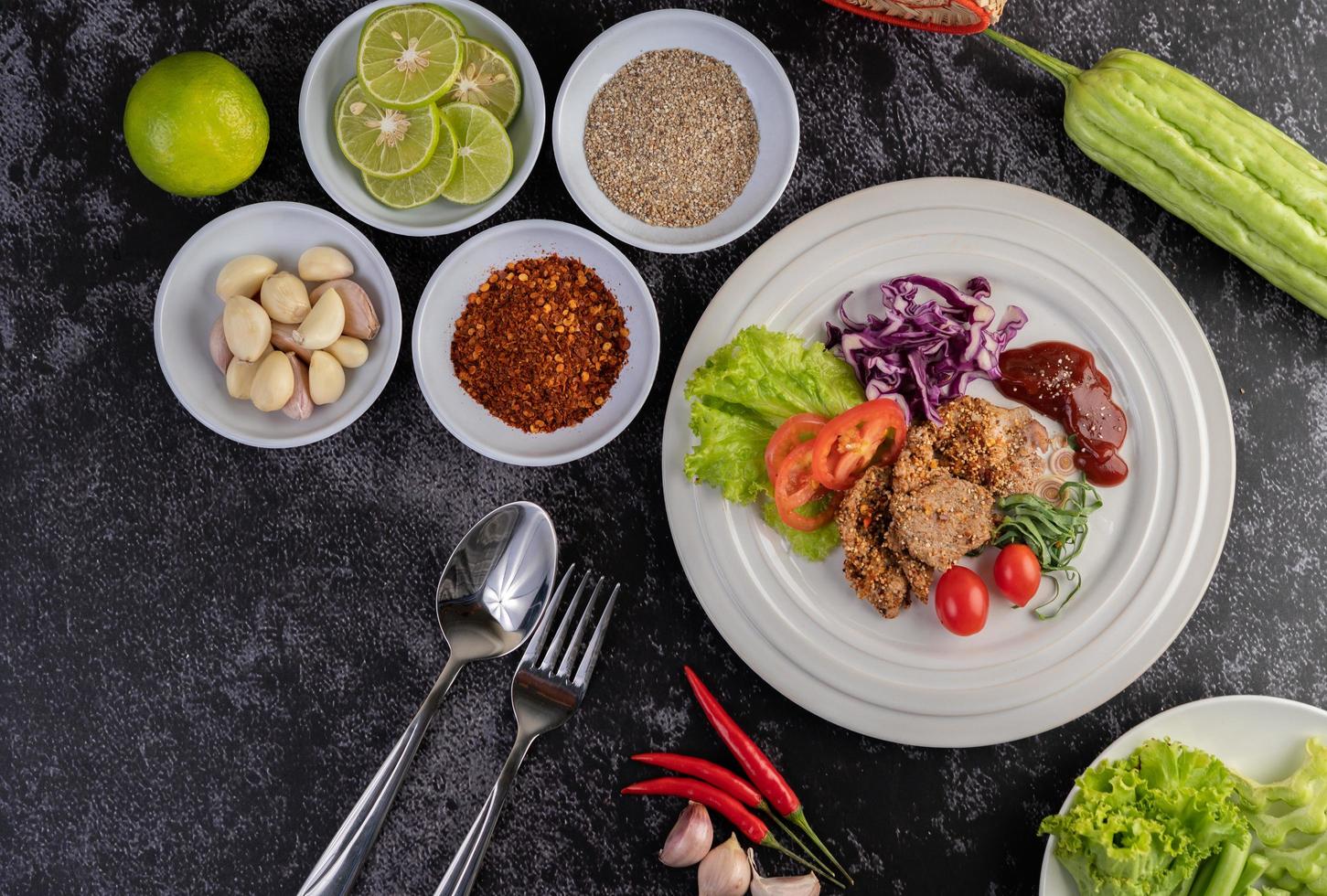 Plated pork salad with galangal, pepper, tomato, lemon and lime photo