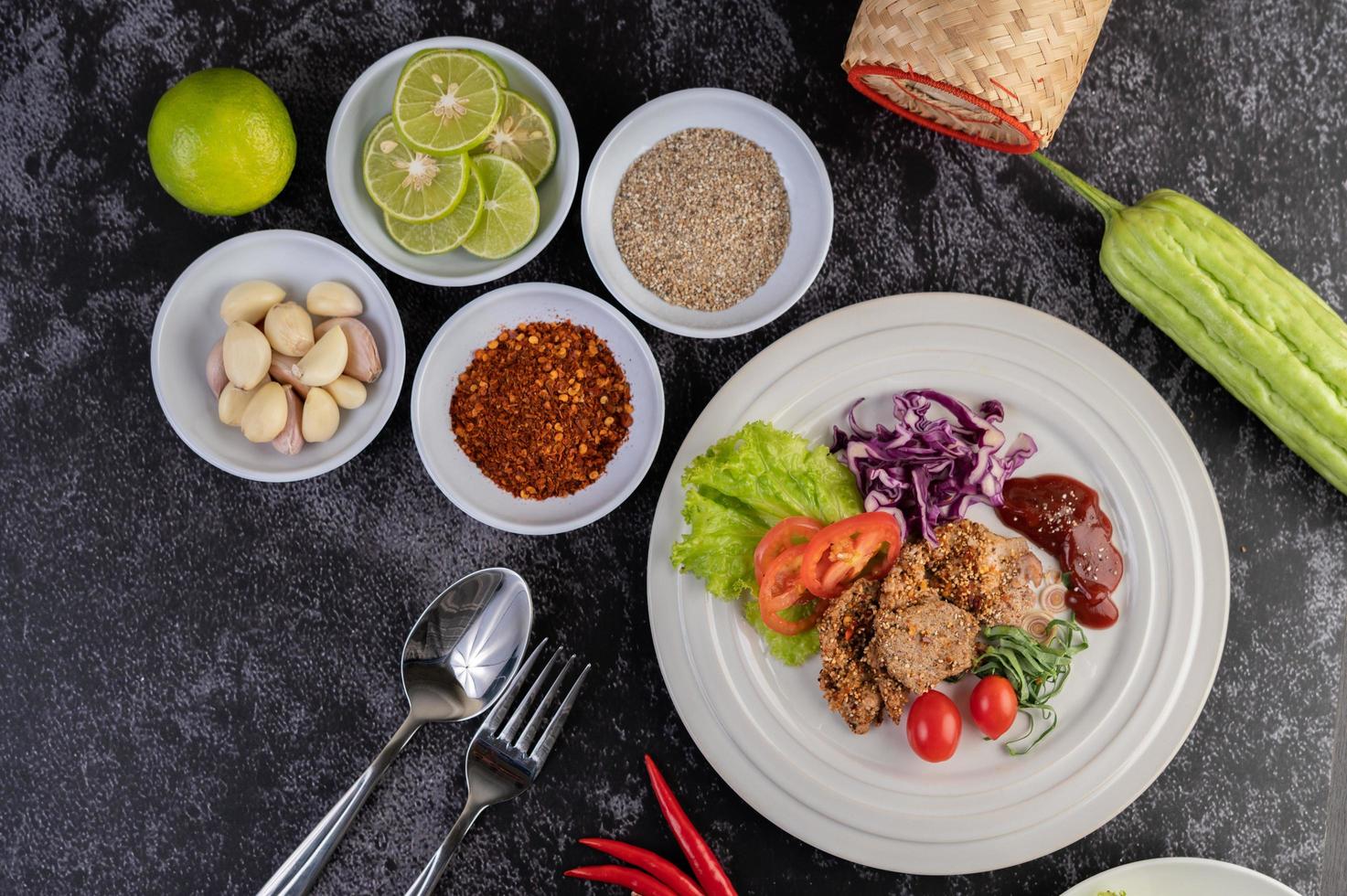 Plated pork salad with galangal, pepper, tomato, lemon and lime photo