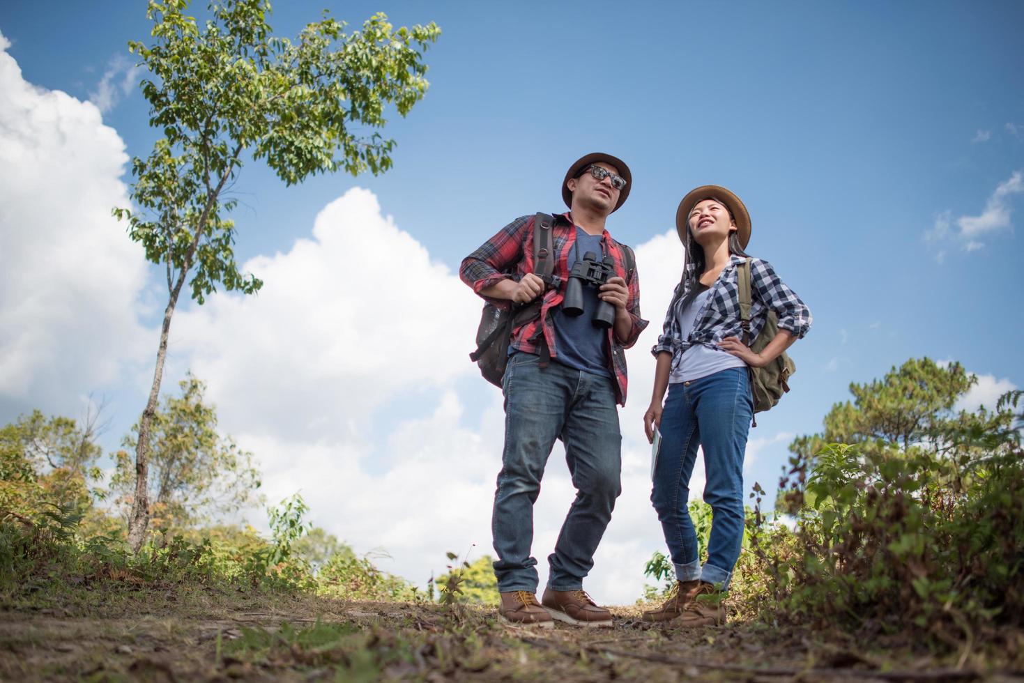 Two young travelers with backpacks in green jungle photo