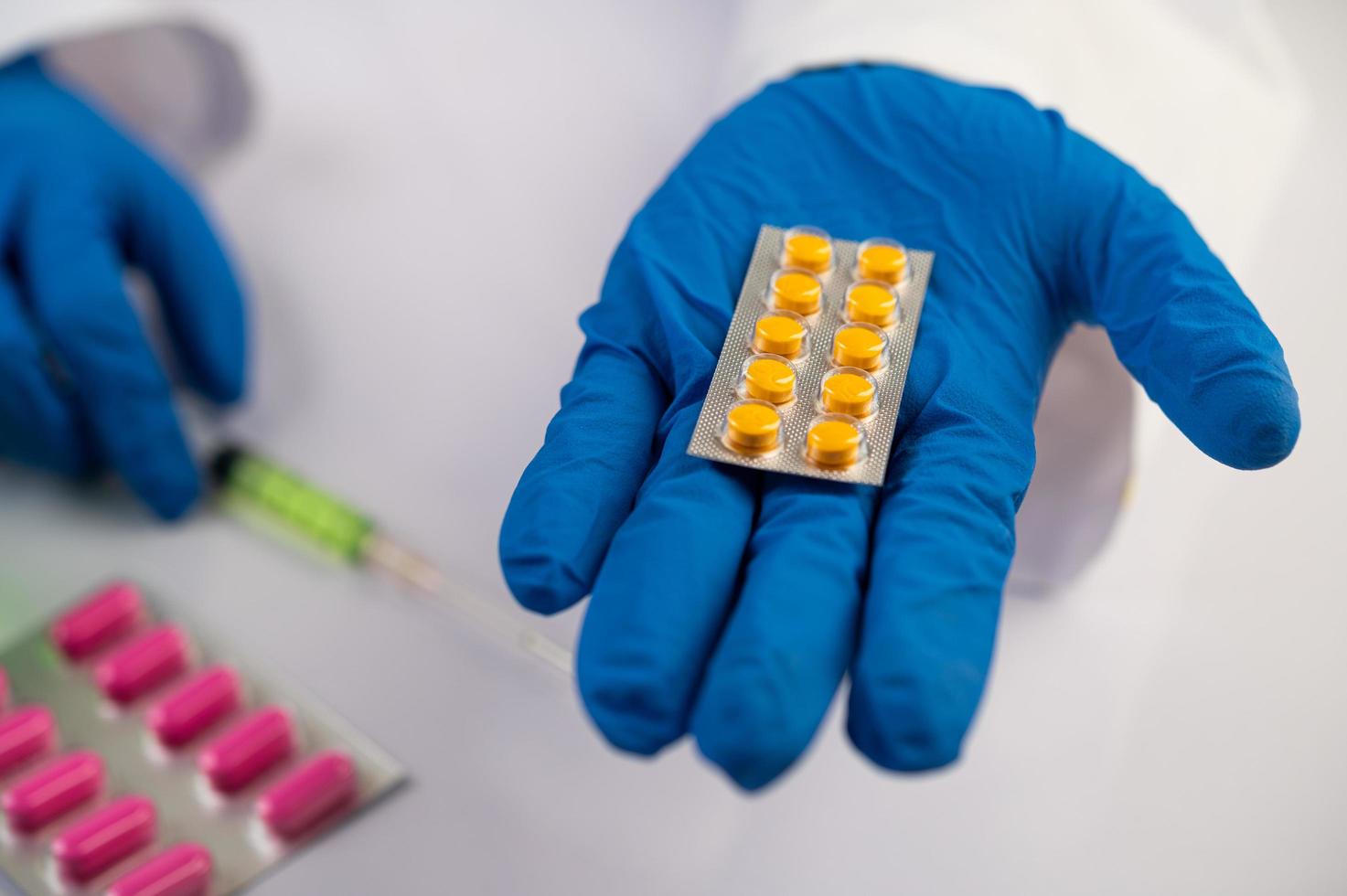 Doctor wears gloves and holds medicine panels photo