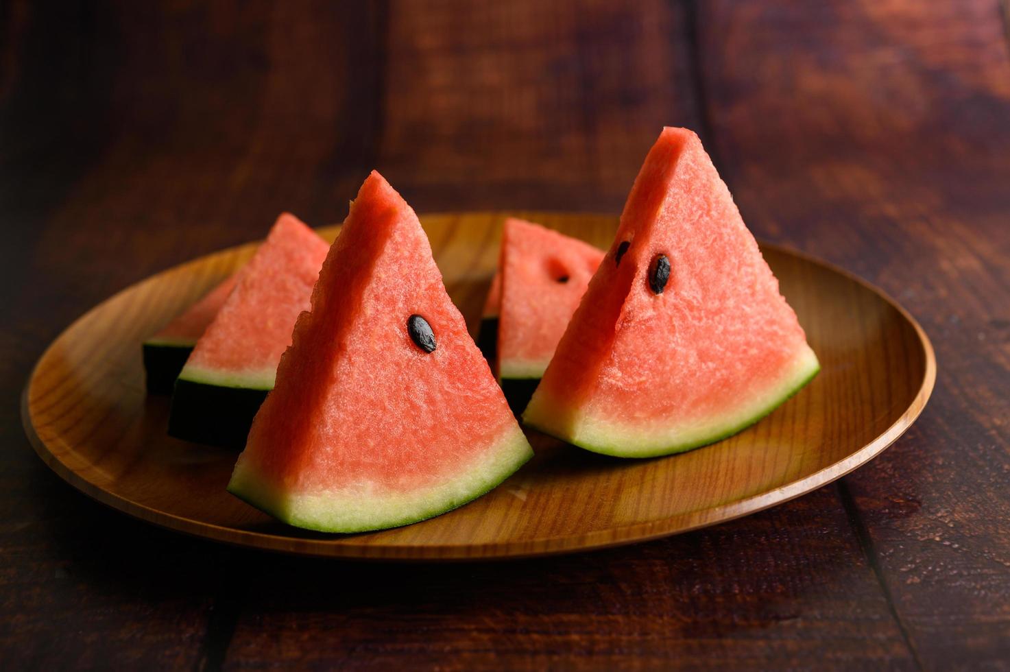 Watermelon cut into pieces on a wooden table photo