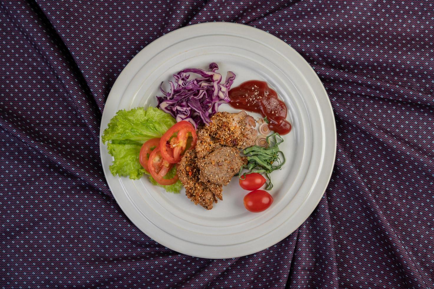 Plated pork salad with peppers, tomato, lemon, lime, garlic and salad photo