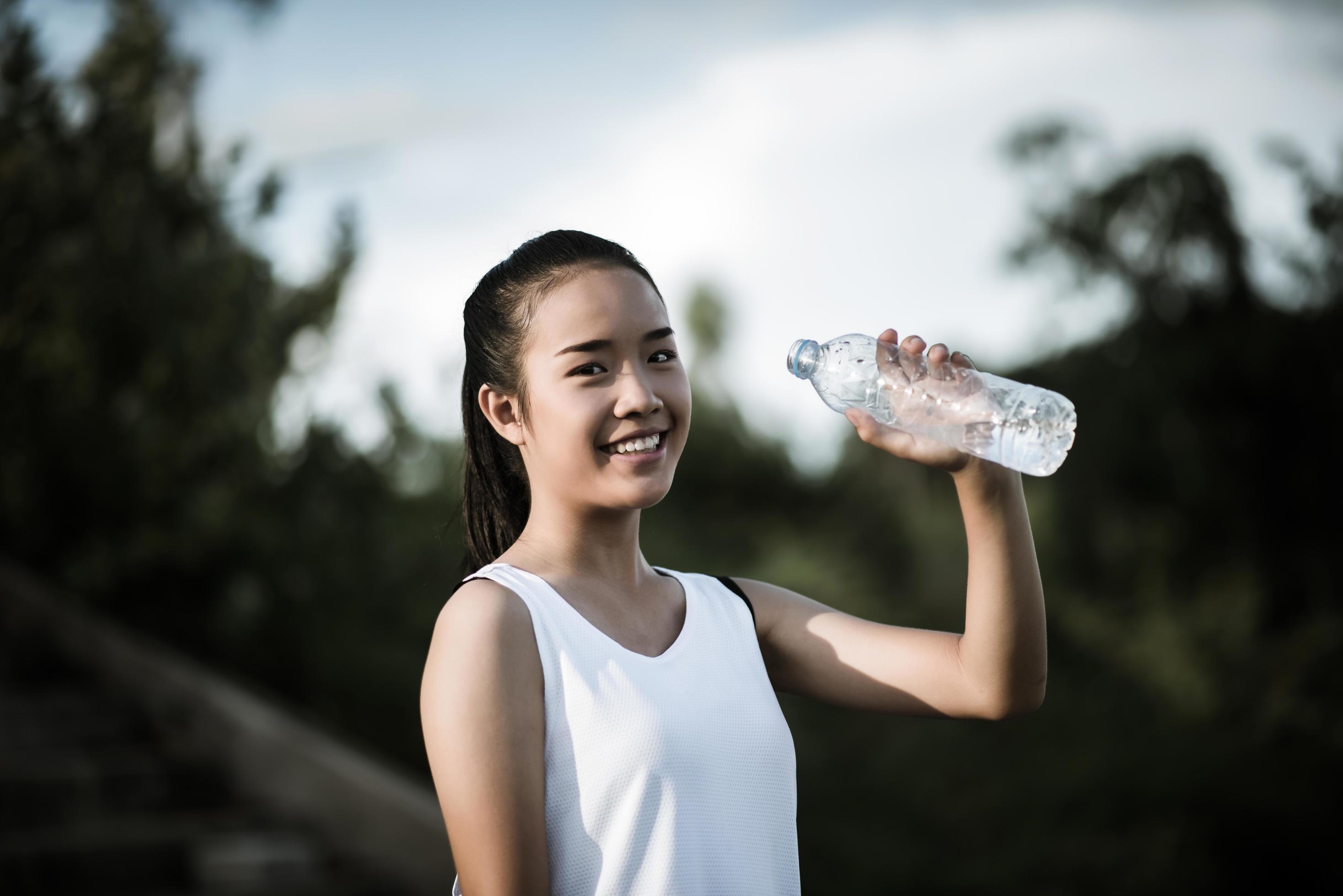 Young fitness teen holding water bottle after running exercise