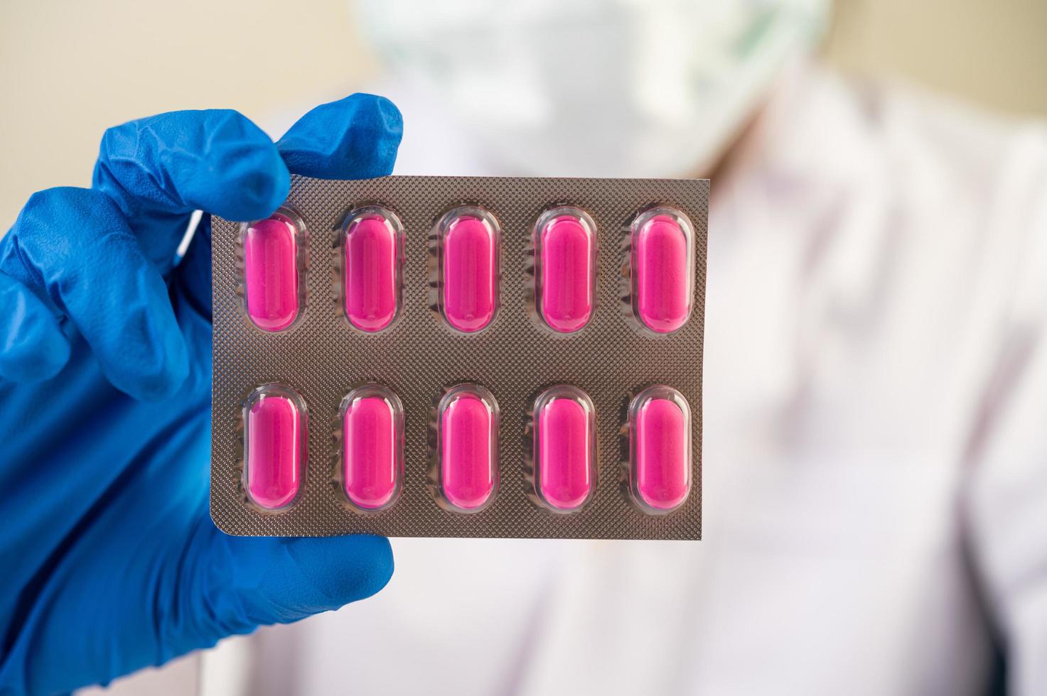 Doctor wears gloves and holds medicine panels photo