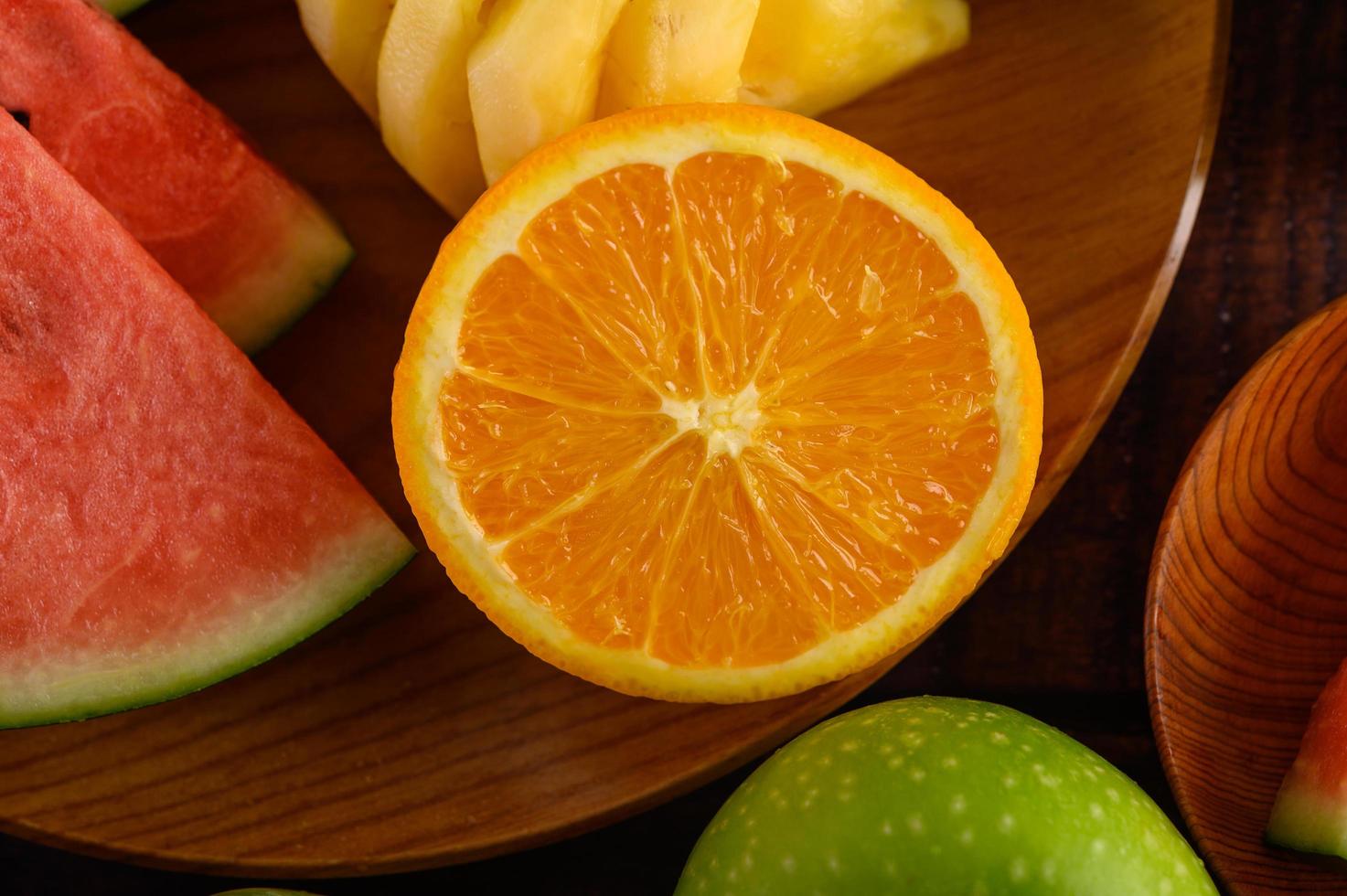 Cut watermelons, oranges and pineapples photo