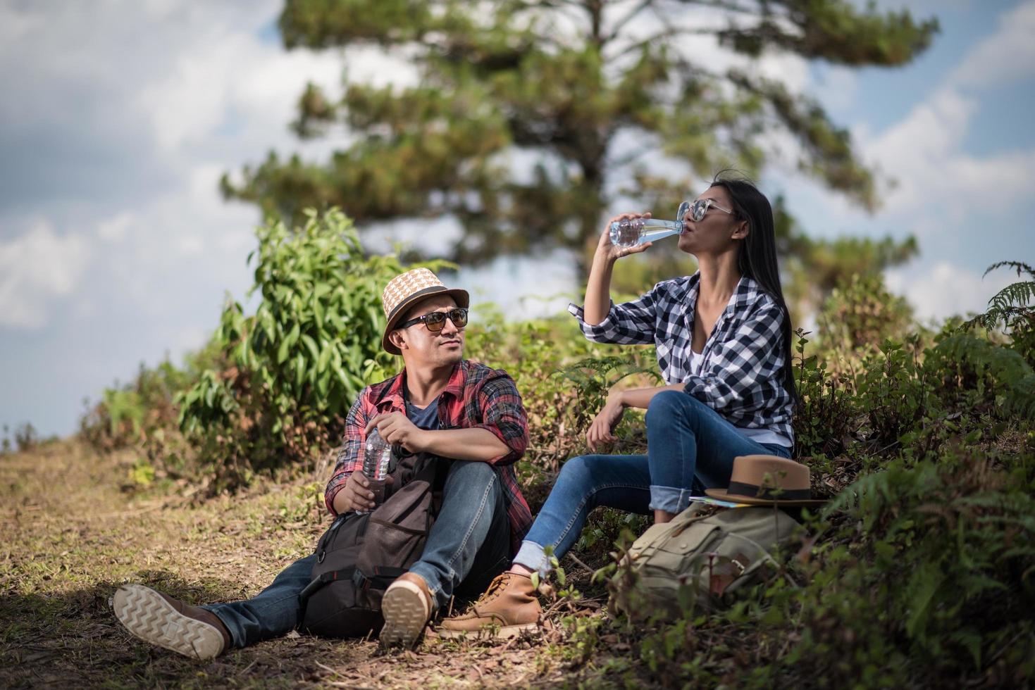 jóvenes excursionistas bebiendo agua en el bosque foto