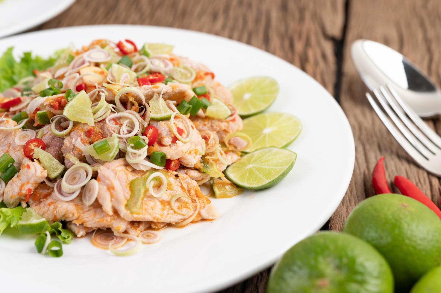 Ensalada picante de cerdo con galanga, limón, ají y ajo foto