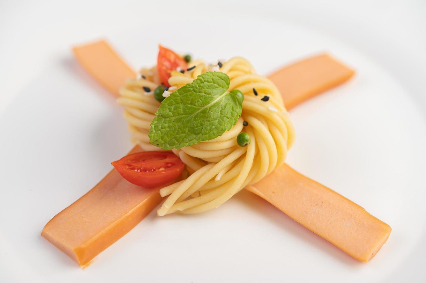 espaguetis gourmet bellamente dispuestos en un plato blanco foto