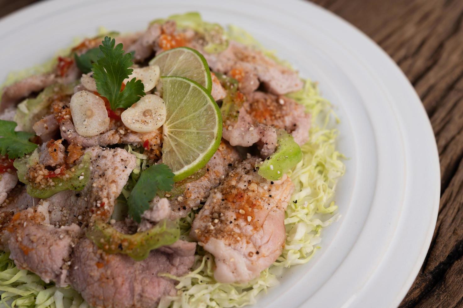 Spicy lime pork salad with galangal, chili and tomatoes photo