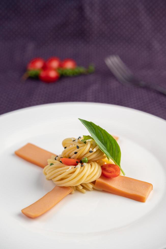 espaguetis gourmet bellamente dispuestos en un plato blanco foto