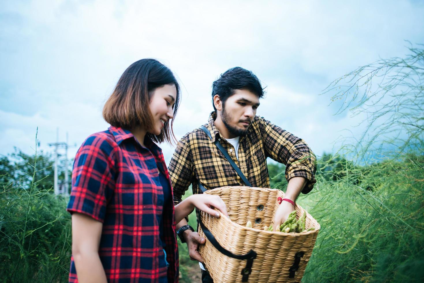 Young farmer couple harvesting fresh asparagus photo