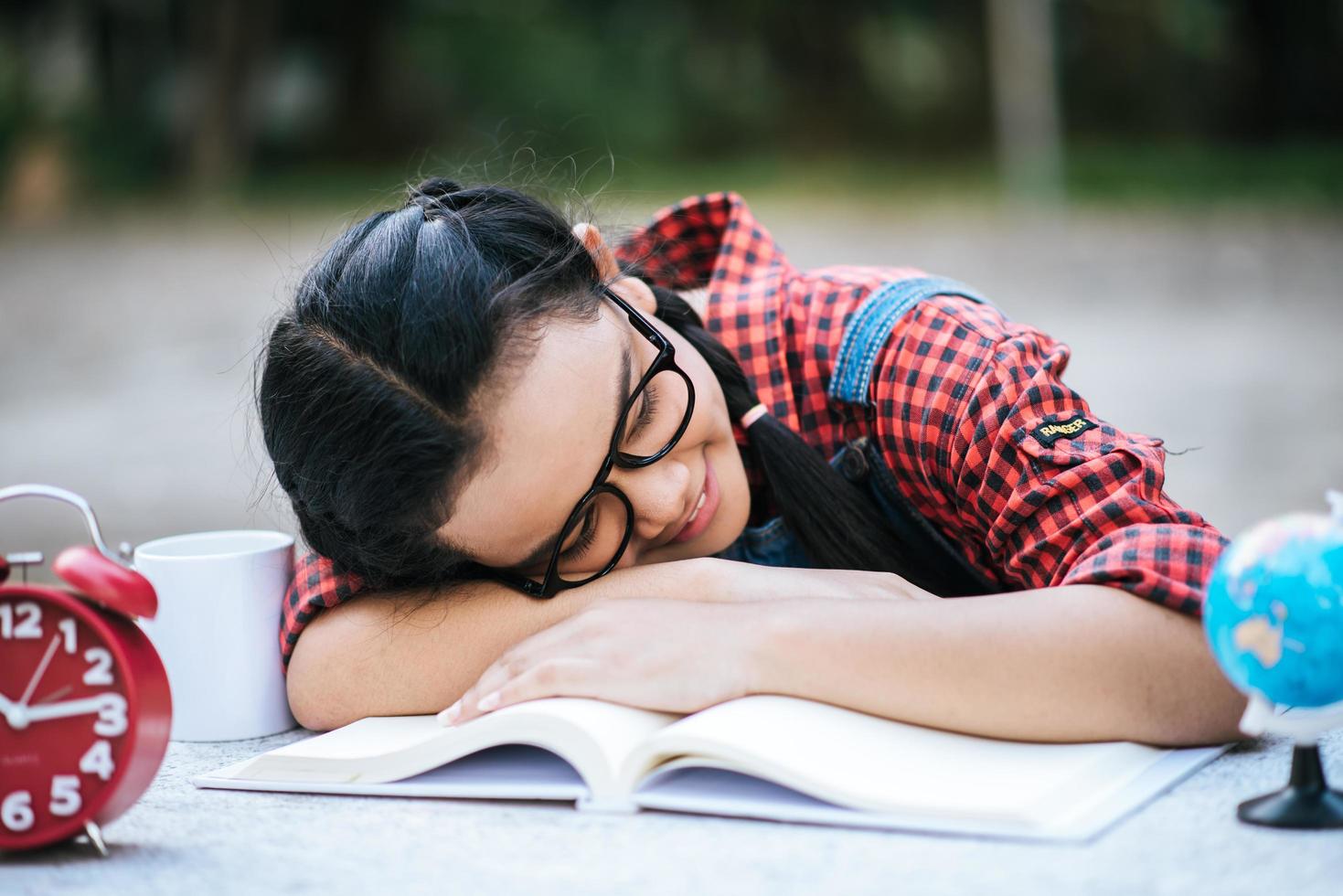 Young girl lying down on desk after reading a book outside photo