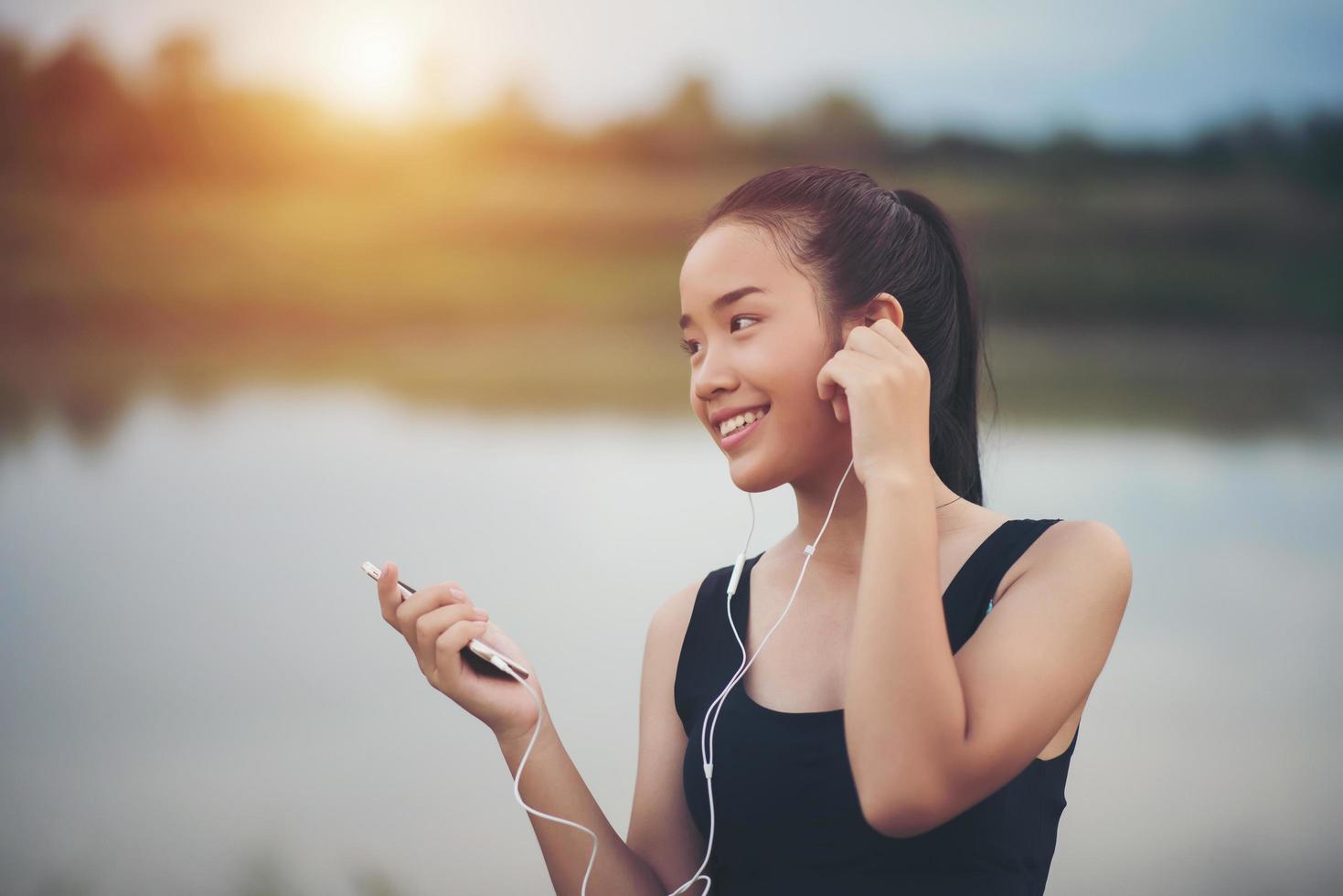 Adolescente fitness con auriculares escuchando música durante su entrenamiento foto