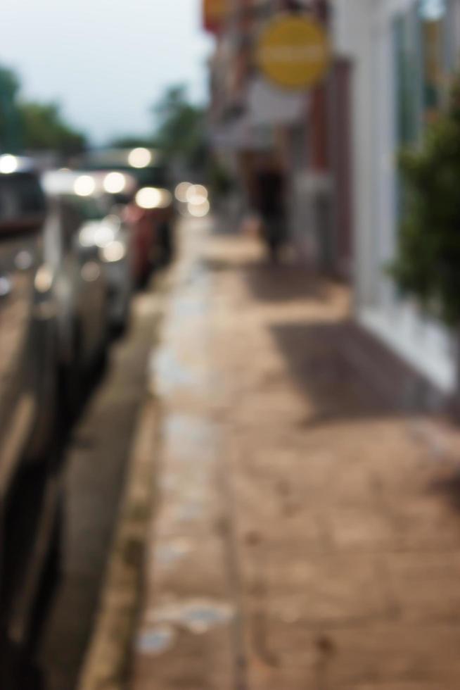 Blurred sidewalk and cars photo