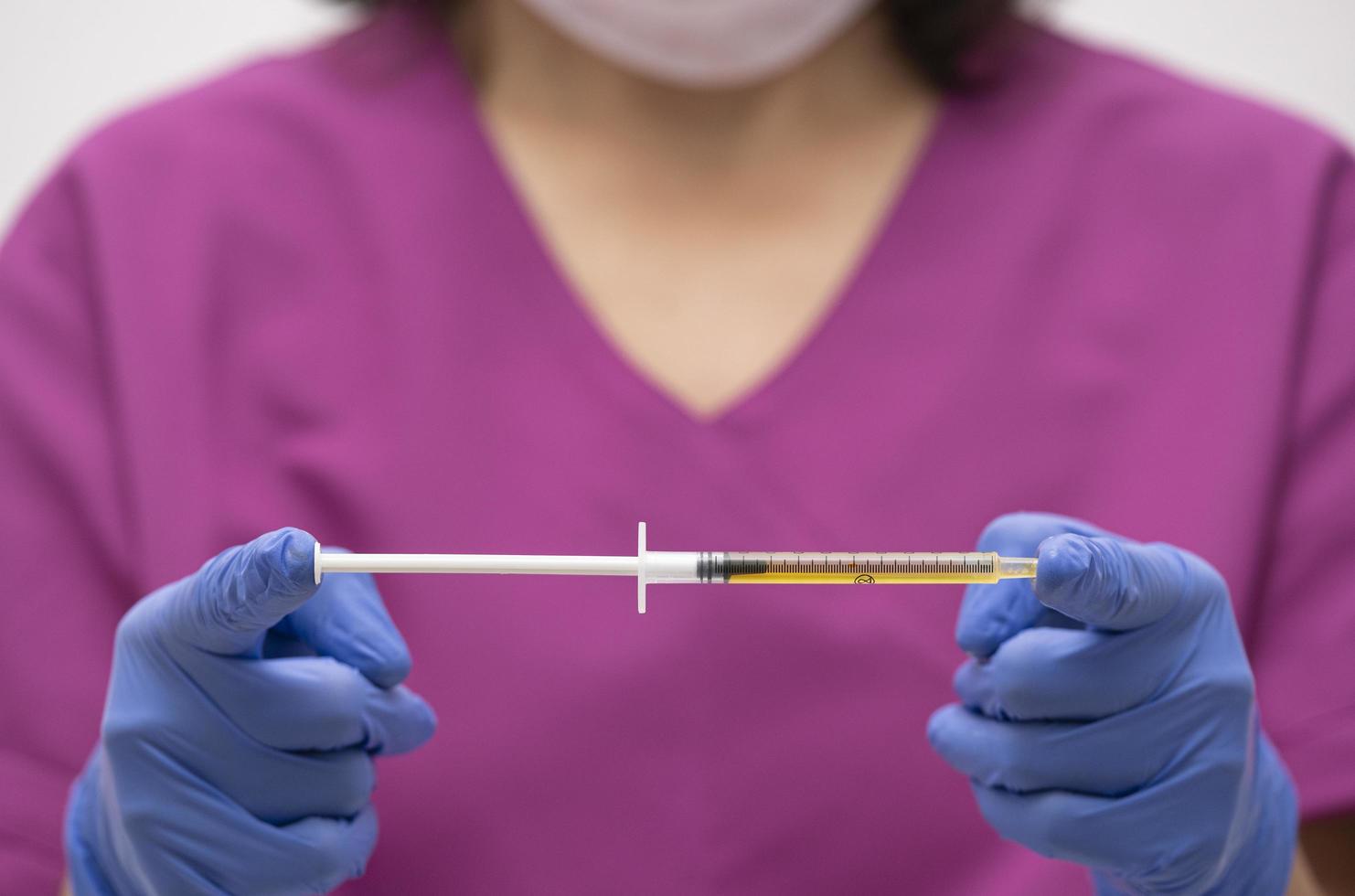 jeringa, inyección médica en mano, palma o dedos. kit de vacunación de plástico con aguja. enfermera o doctor. Drogas líquidas o narcóticas. atención médica en el hospital. foto