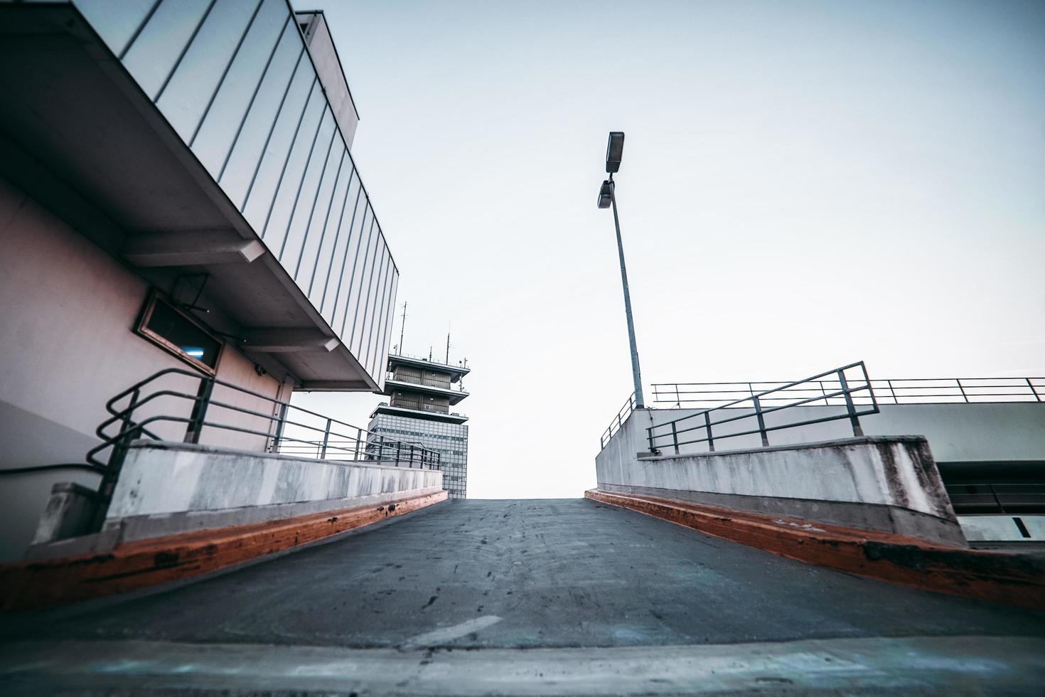 Asphalt road between buildings under gray sky photo