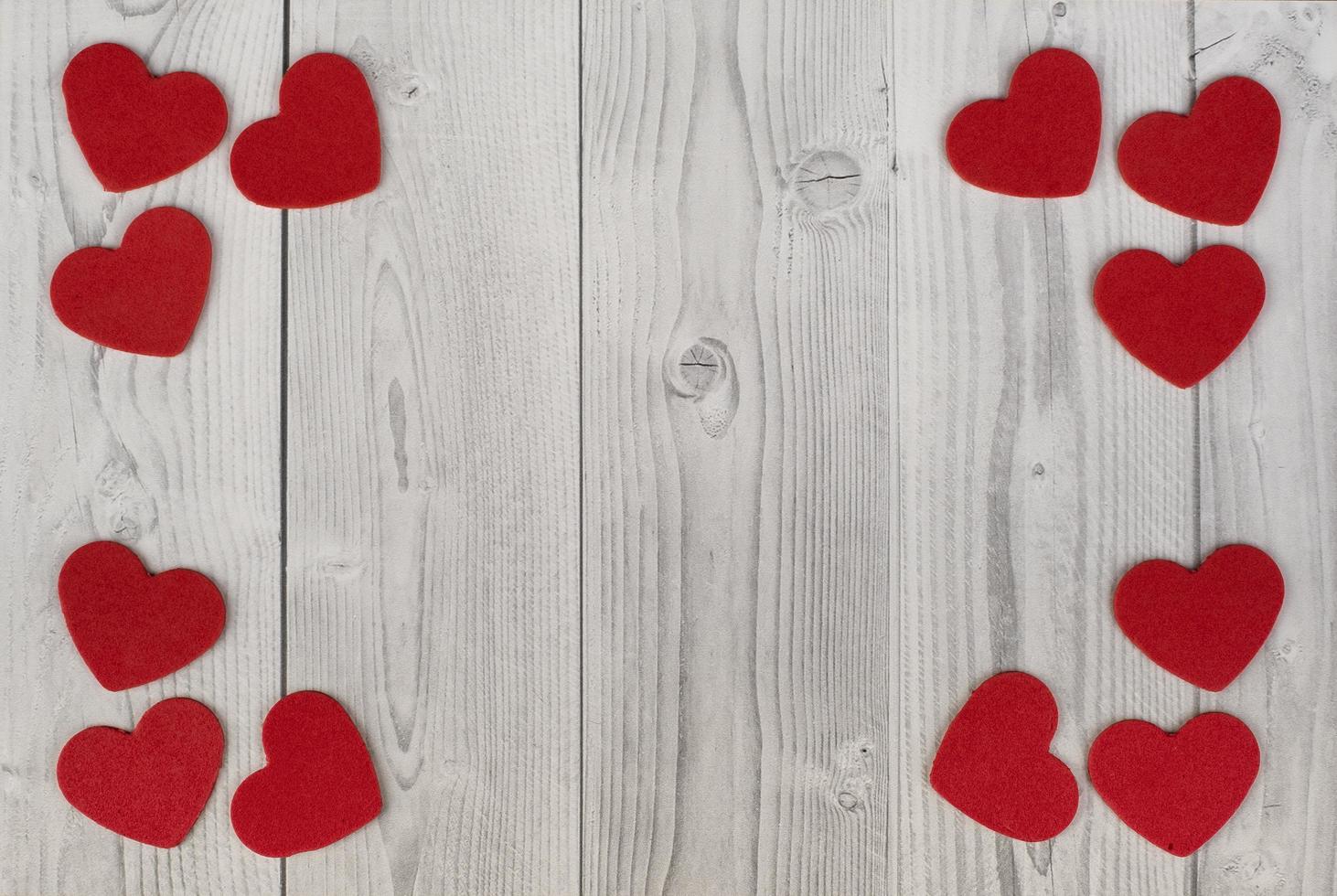 Red hearts in the corners of a white and grey wooden background. concept of valentines day photo