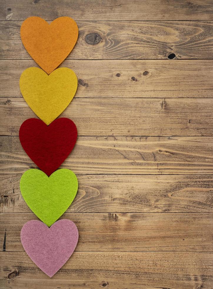 Colored hearts in a row down on a walnut wood background. Concept of St. Valentine's Day photo