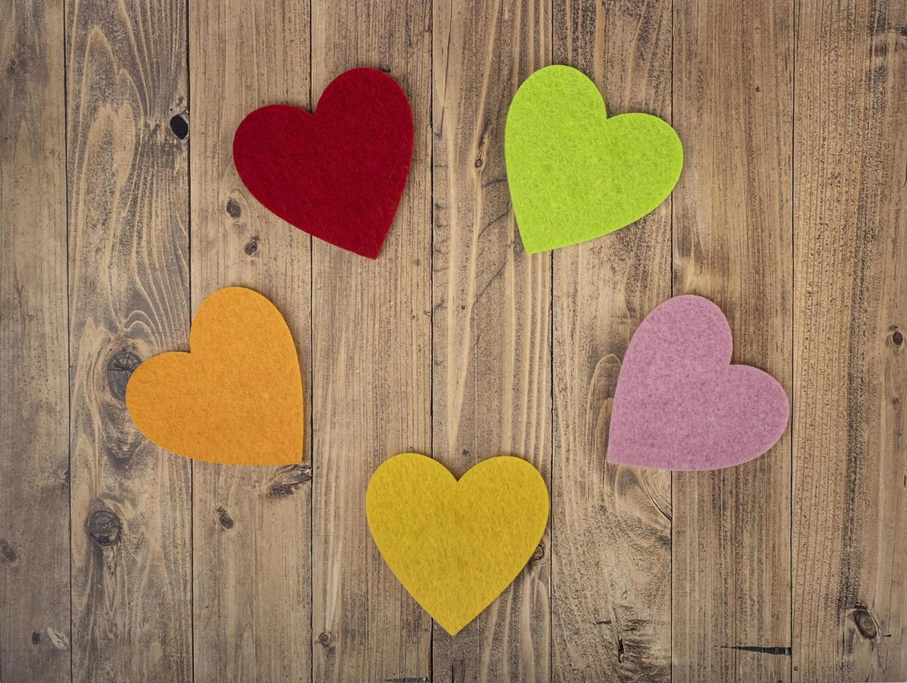 Coloured hearts forming a circle on a walnut wood background. Concept of St. Valentine's Day photo