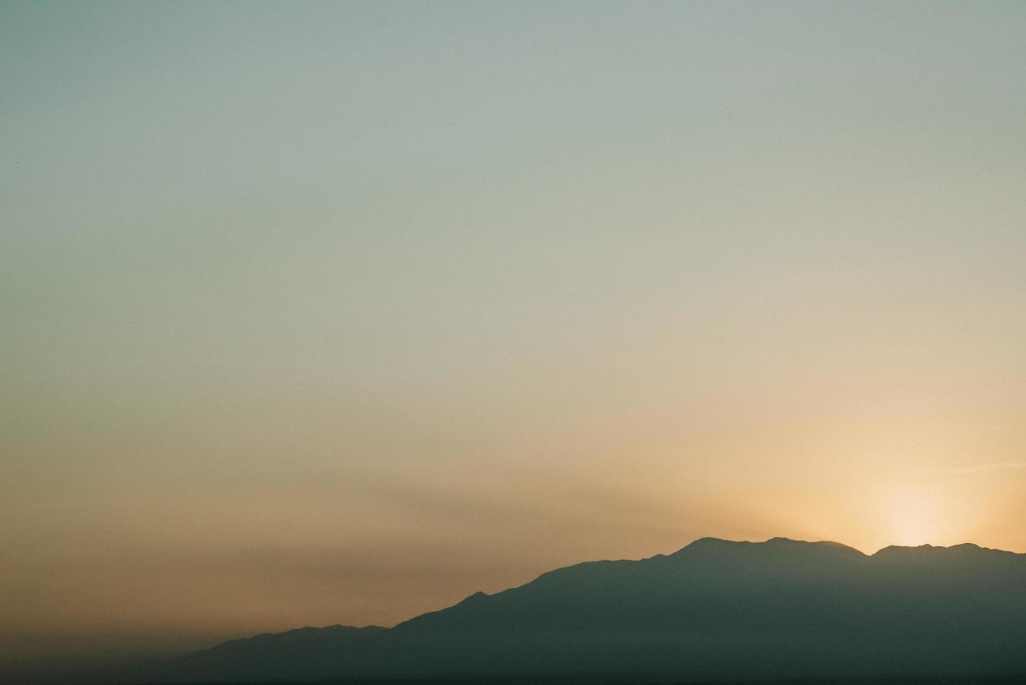 silueta de montaña al atardecer foto