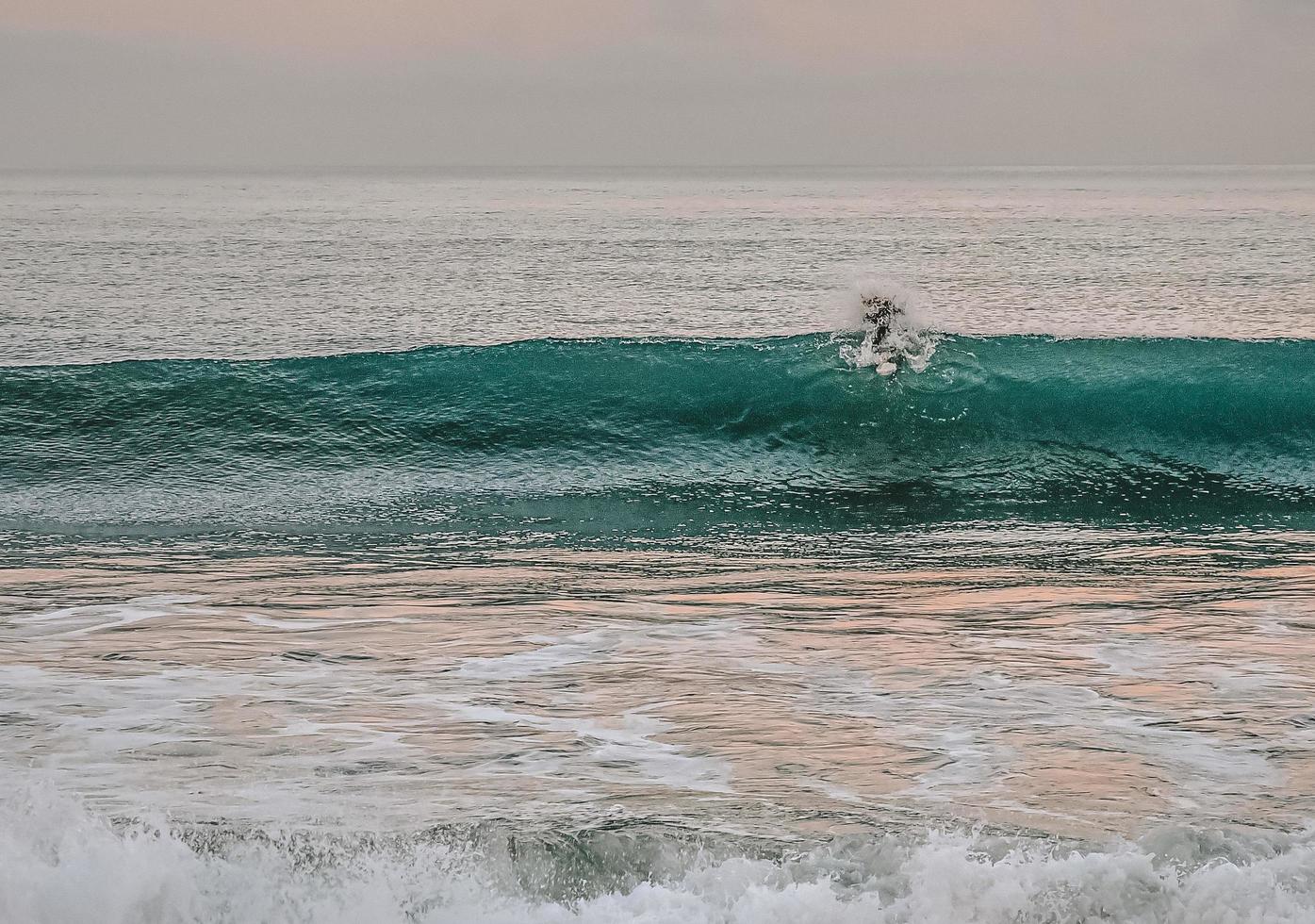Person surfing on sea waves photo