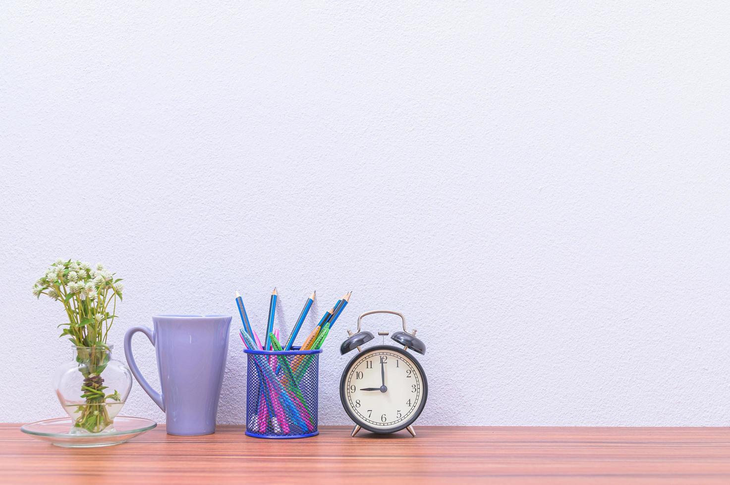 Pencil, pen and clock on the desk photo