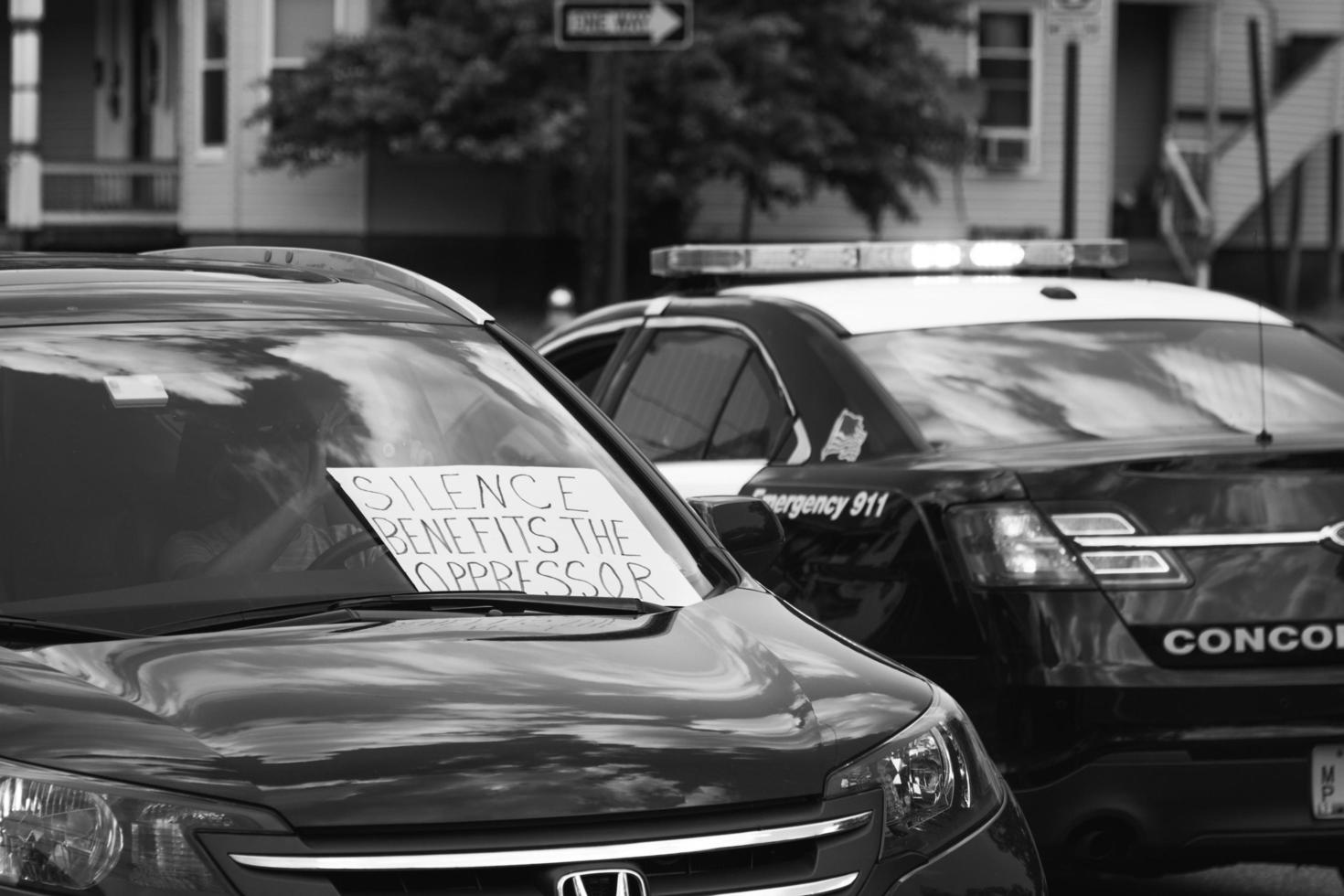 United States, 2020 - Grayscale photo of protest sign on a police car