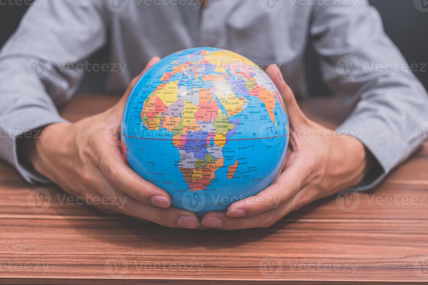 Man holding world globe on table photo