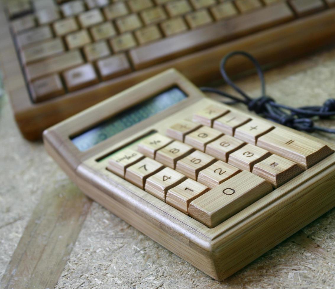 Calculadora digital y teclado de bambú sobre madera foto