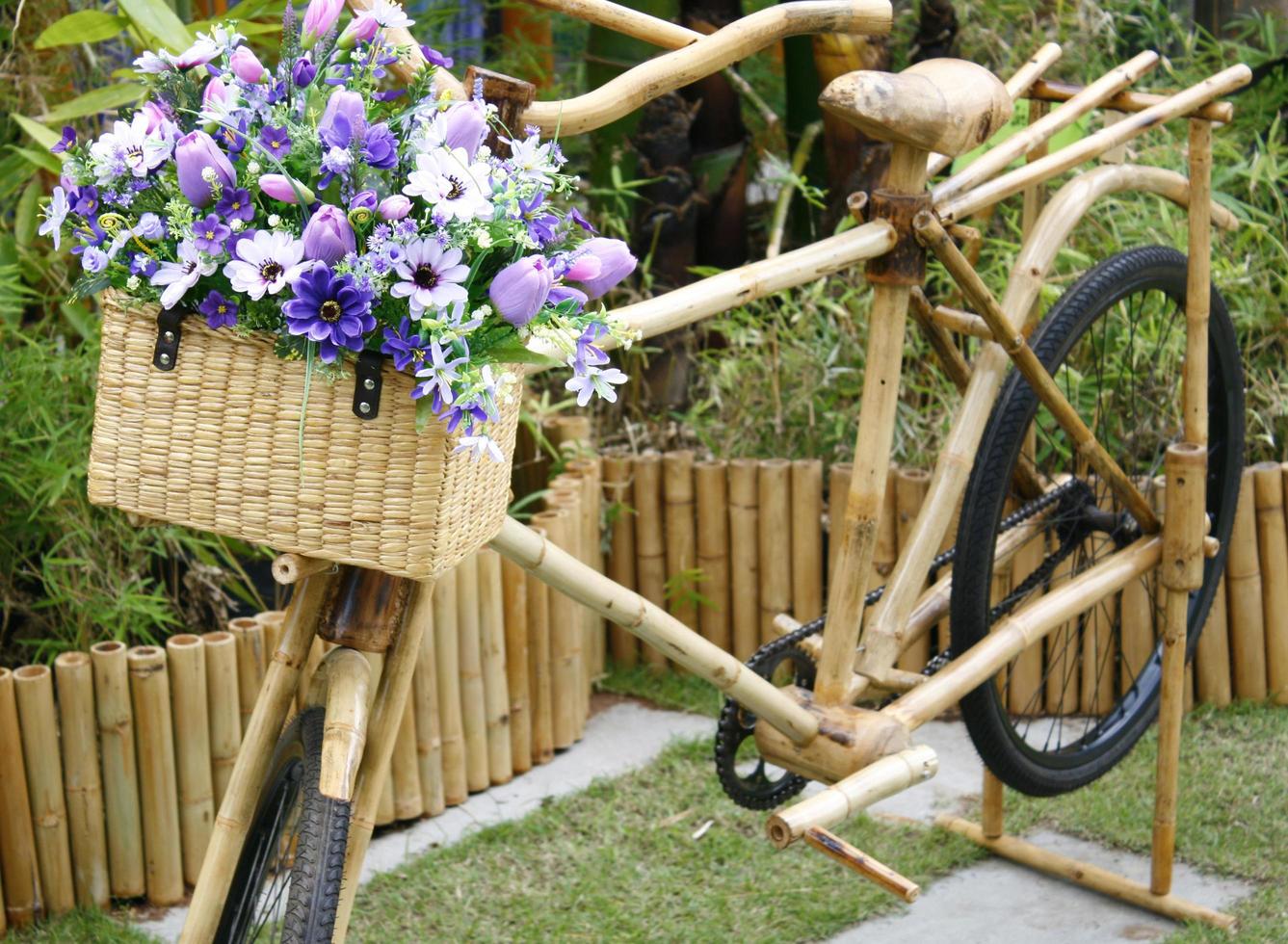 Bicicleta de bambú con ramo en la canasta foto