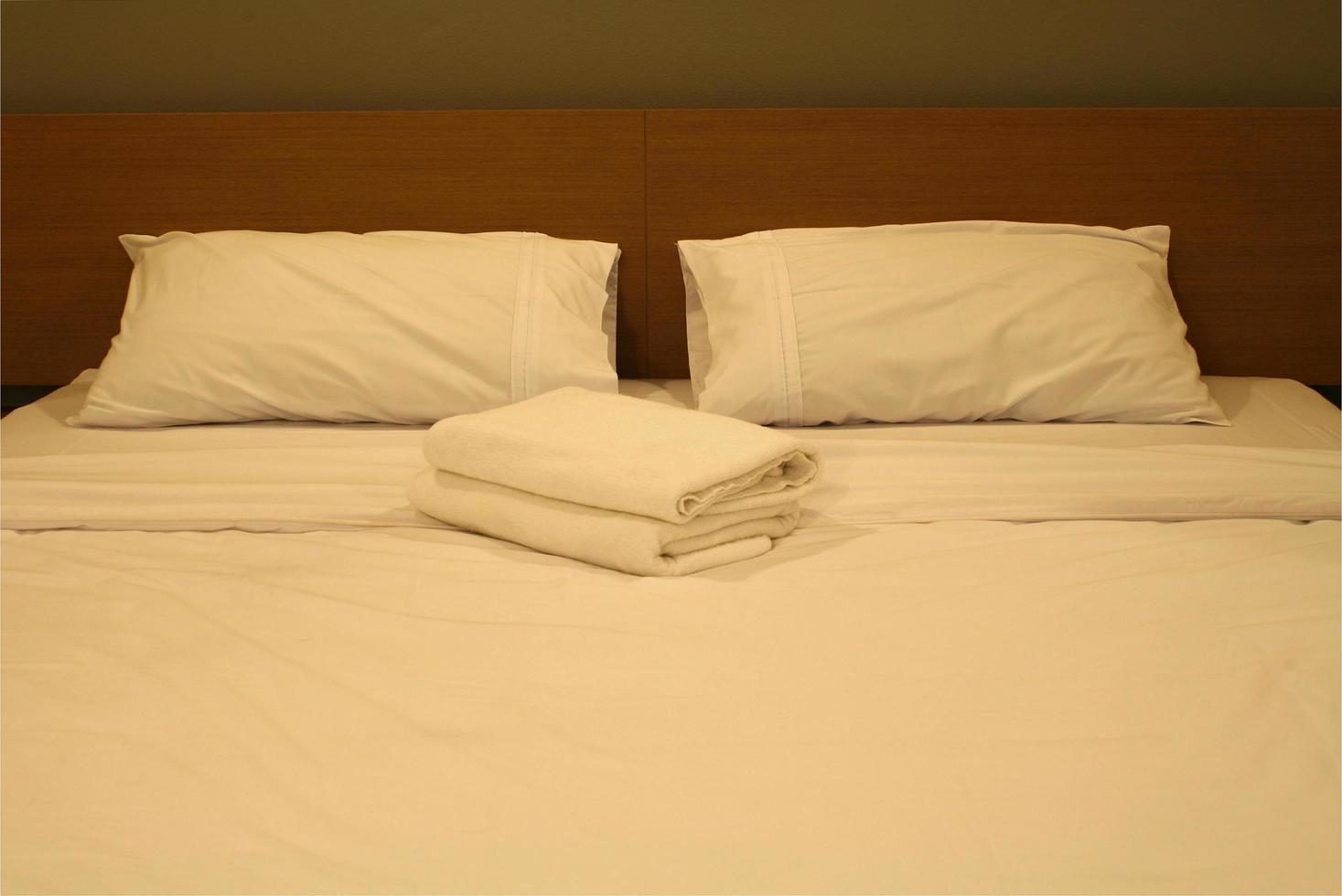 cama de hotel con sábanas blancas foto