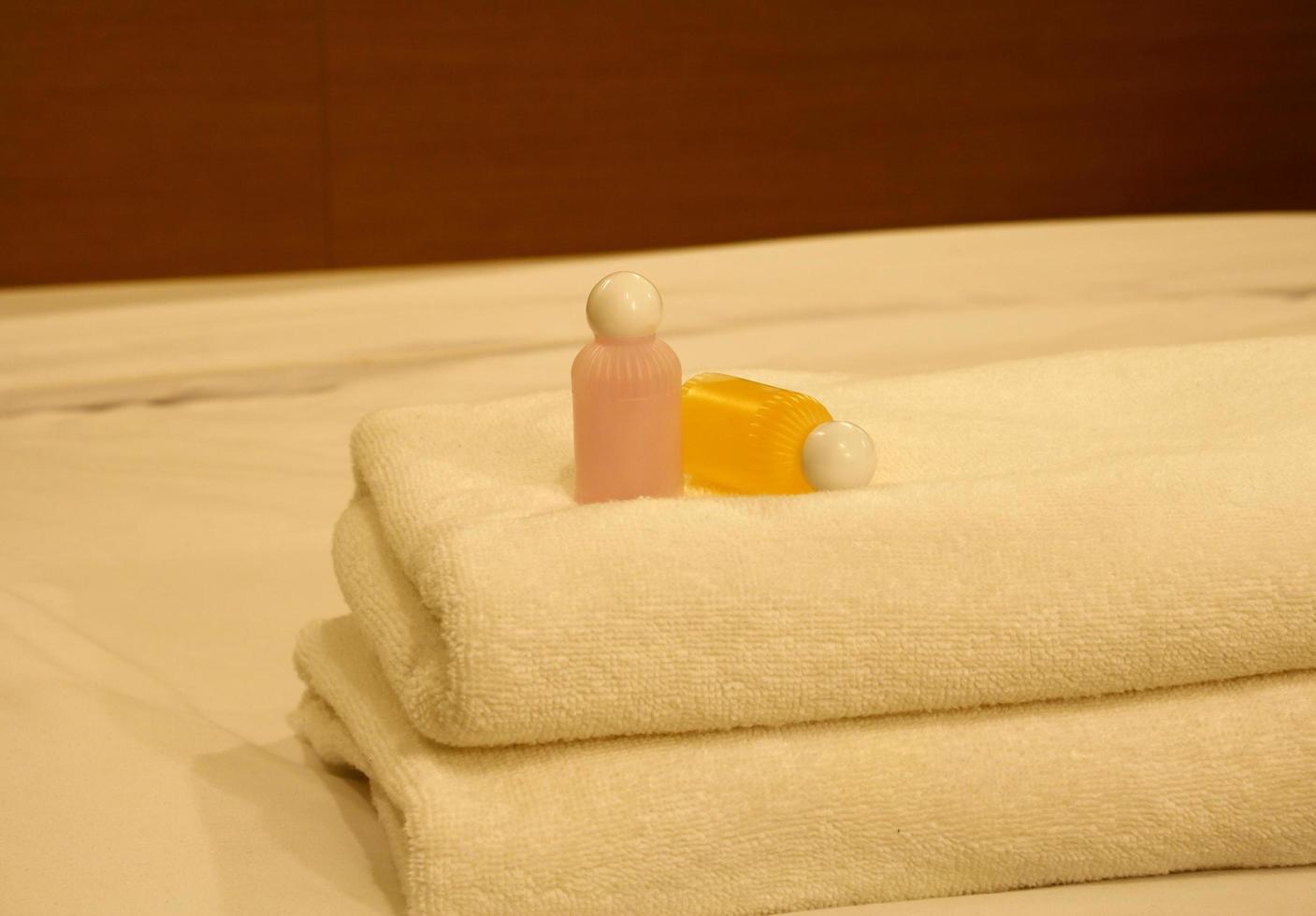 Luxurious bedroom with two towels and shampoo on the bed photo