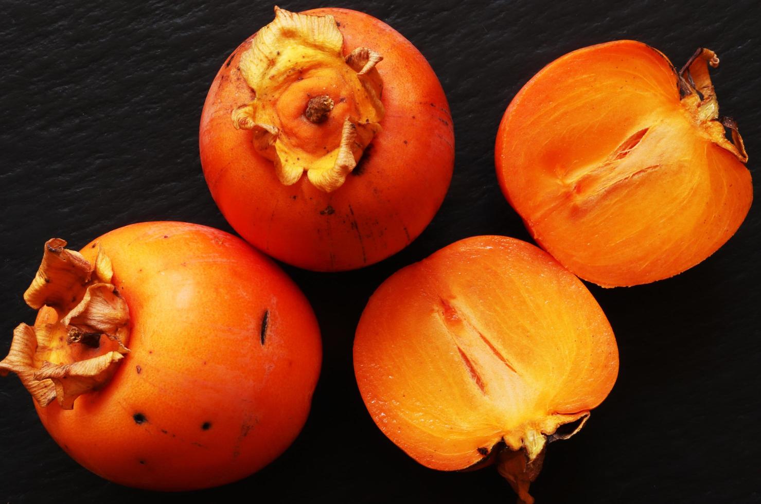Sliced and whole persimmons photo