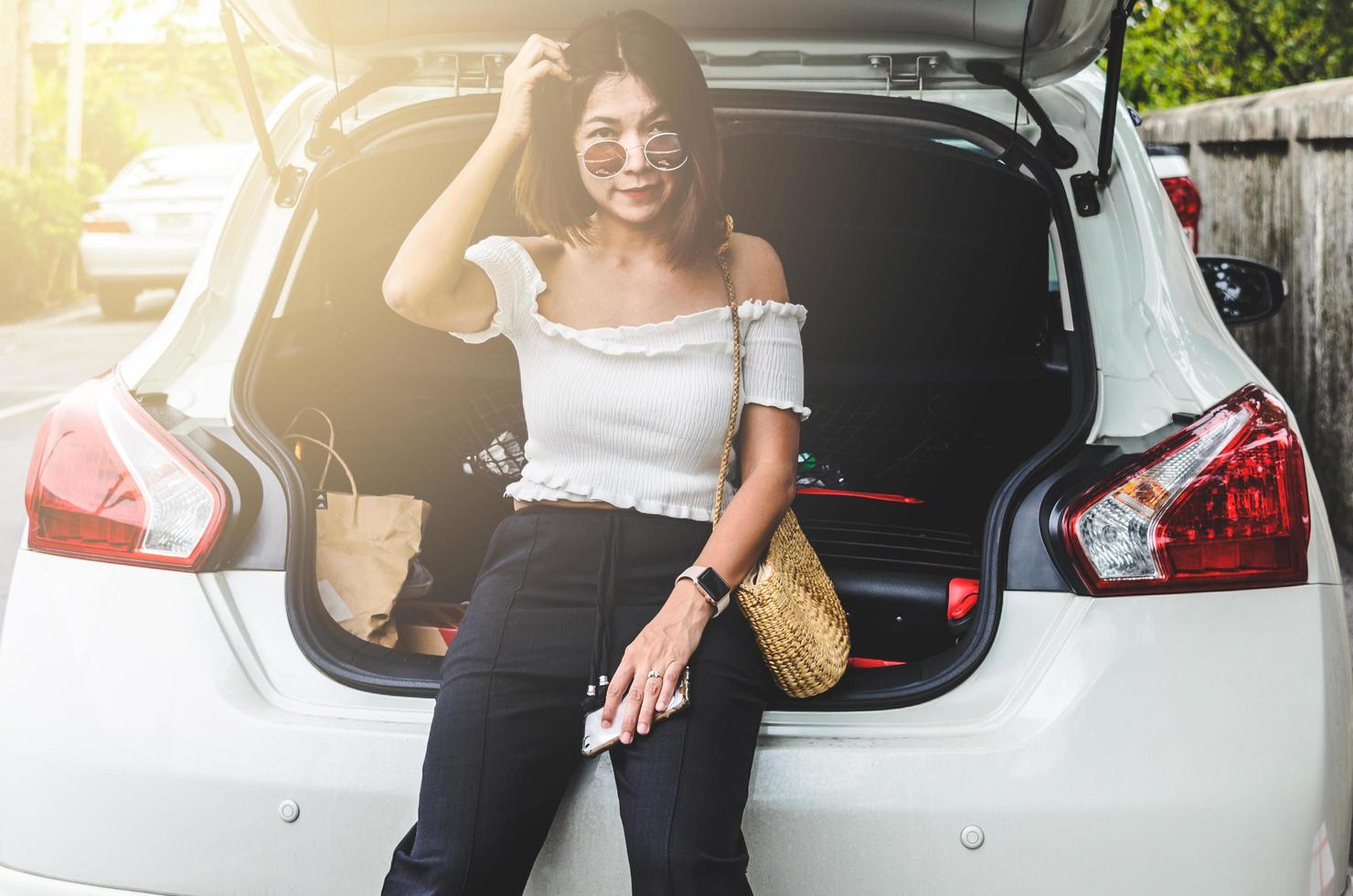 mujer sentada detrás del coche foto