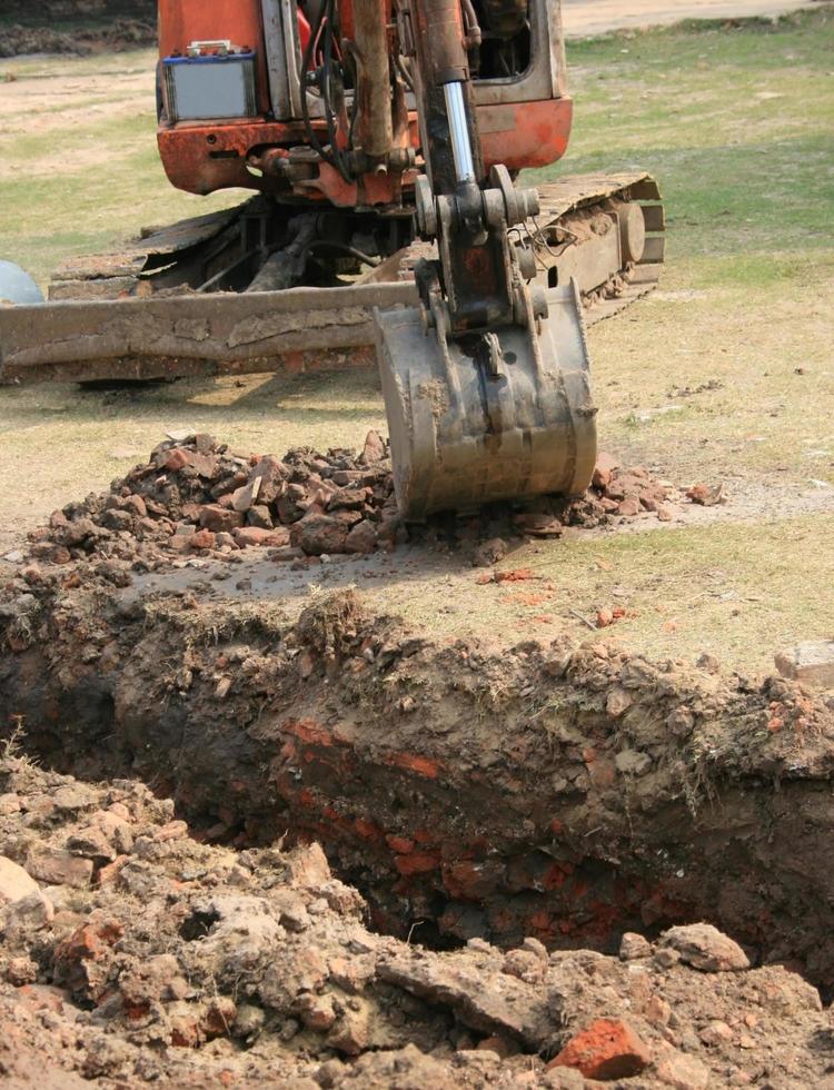 Tractor digging up soil photo