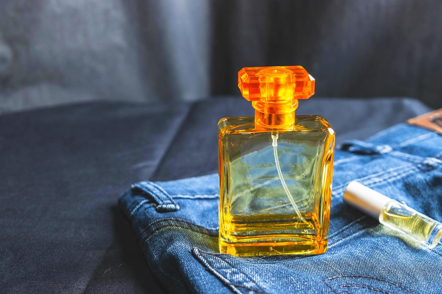 botella de perfume naranja en la mesa foto