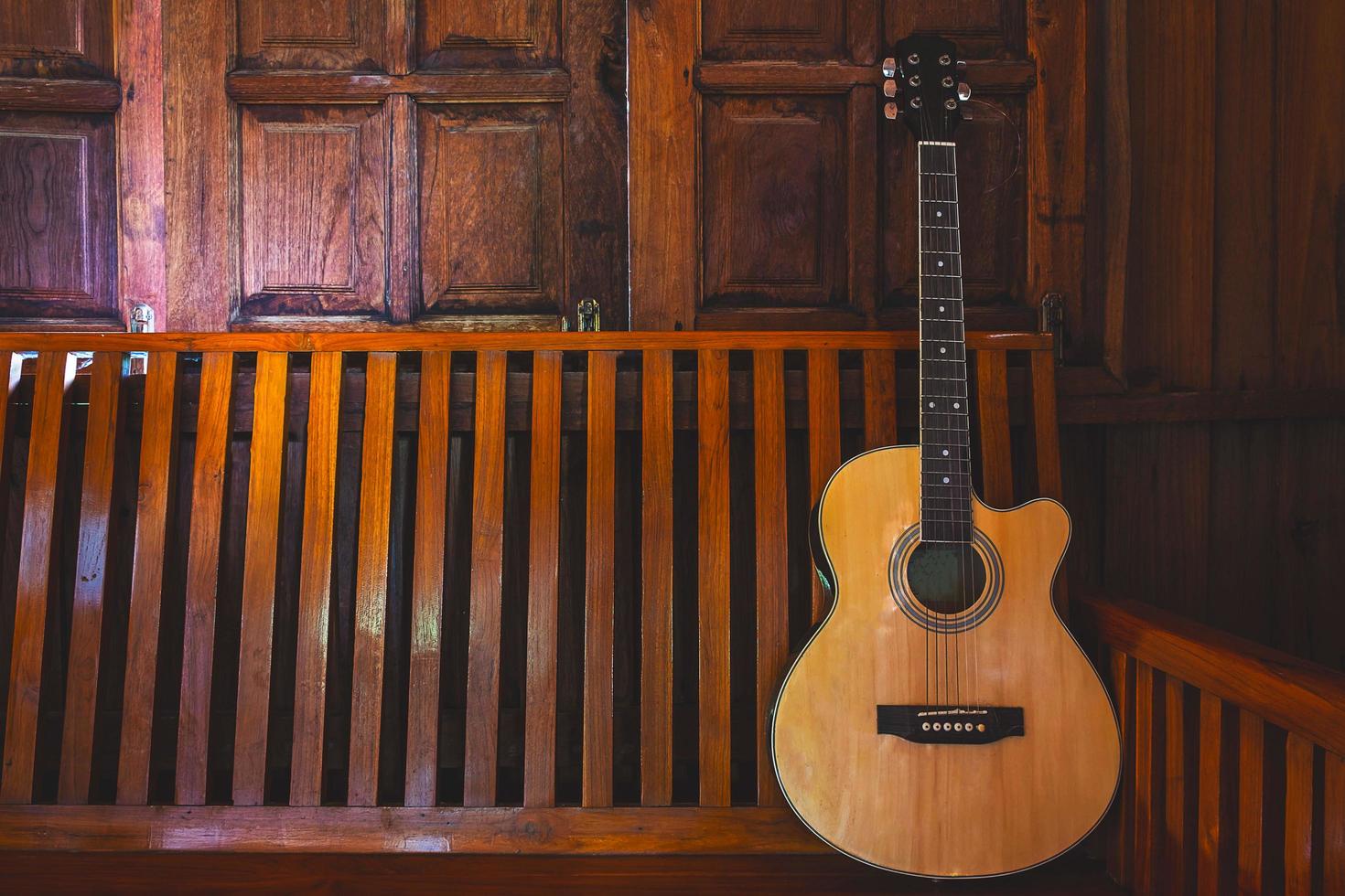 Guitarra acústica colocada sobre suelos de madera. foto