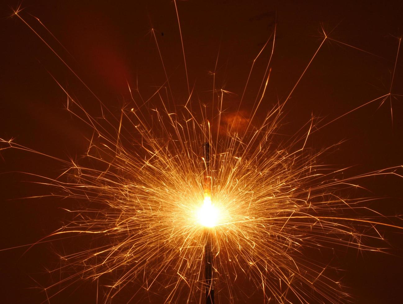 Orange sparkler in night sky photo