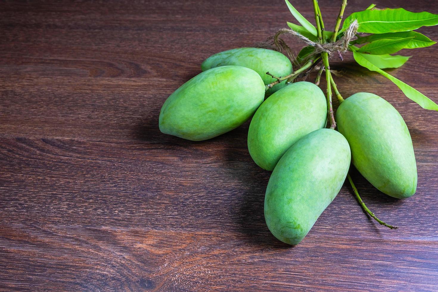 Fresh green mango fruit on a wooden table photo
