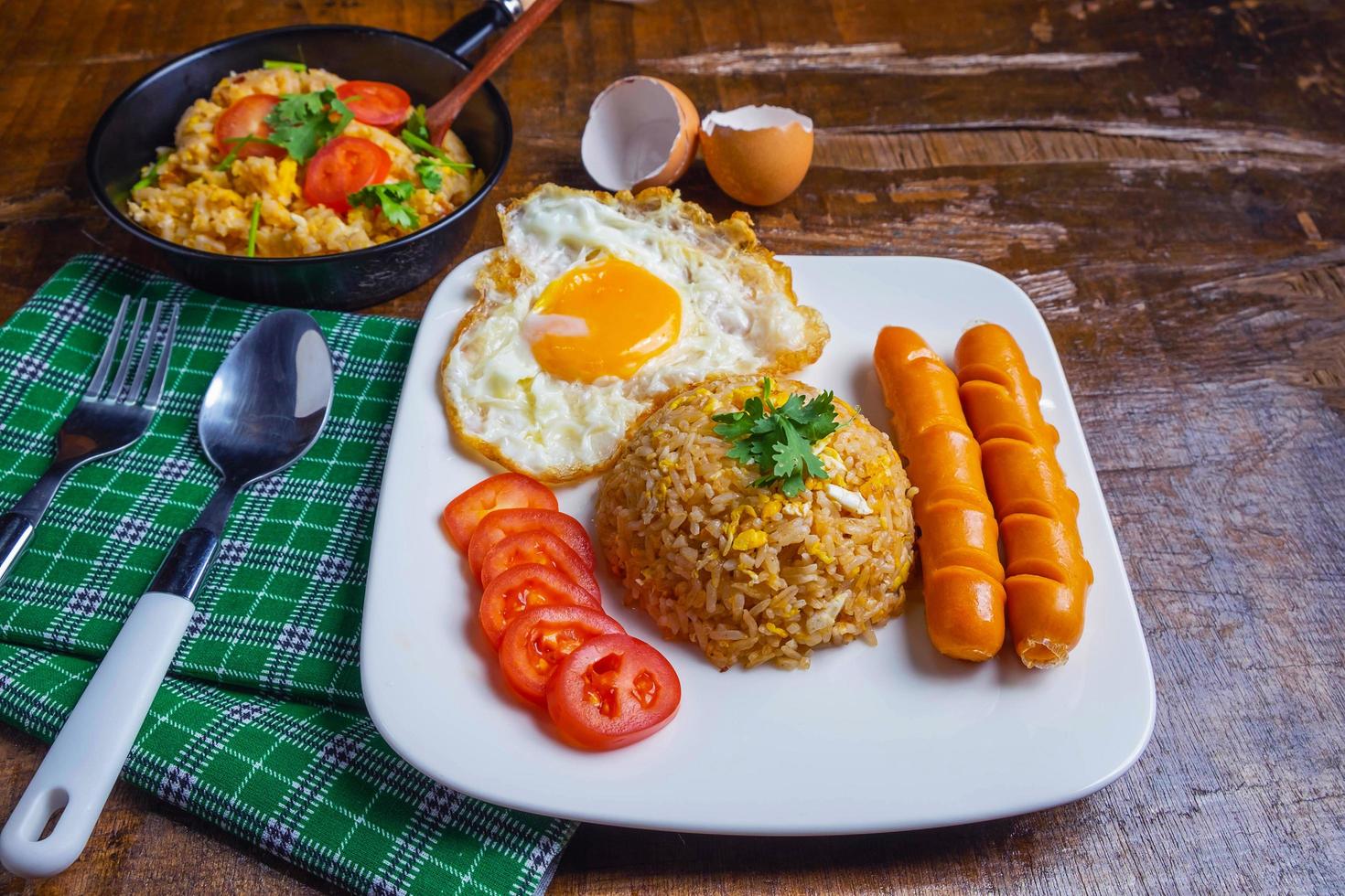 arroz frito servido con huevos y salchicha foto