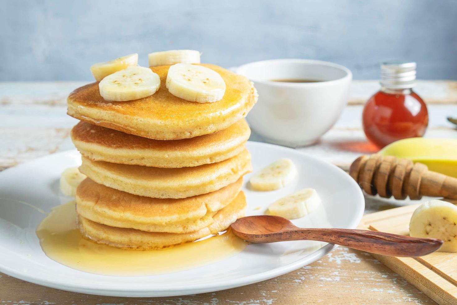 Pancakes topped with honey and bananas photo