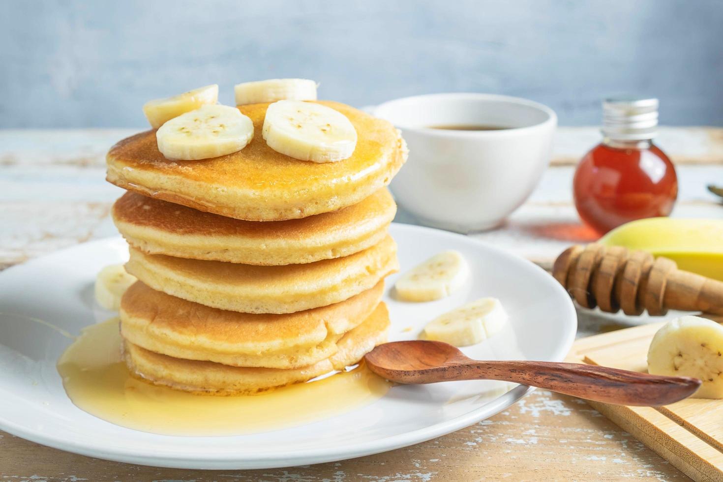 panqueques cubiertos con miel y plátanos foto