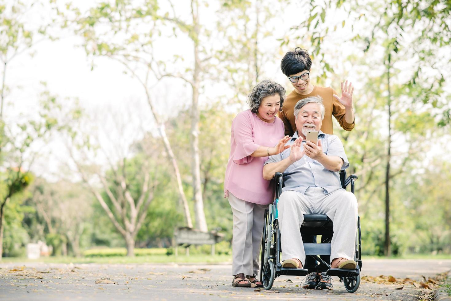 Family having fun using smartphone in park photo