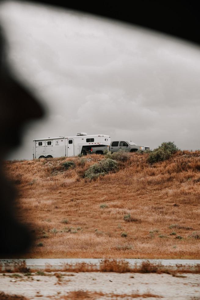 White rv trailer on brown grass field photo