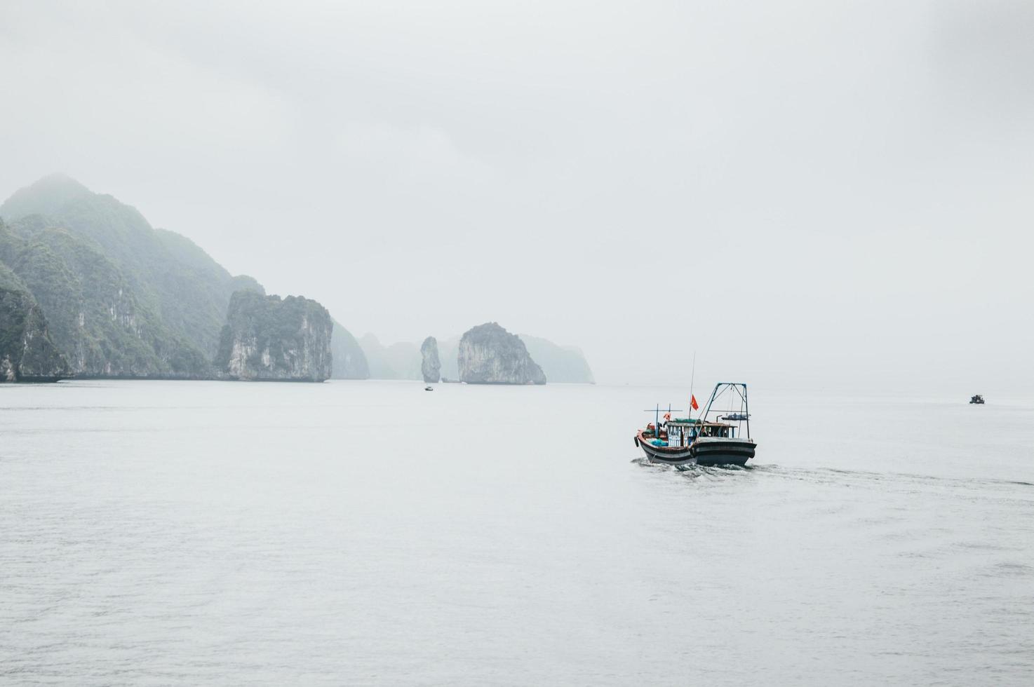black and white boat near rock formation photo